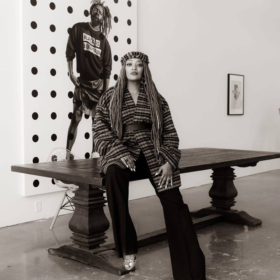 Daisha Board, founder of Daisha Board Gallery, seated in the gallery